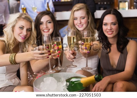 Pretty friends drinking champagne together at the bar