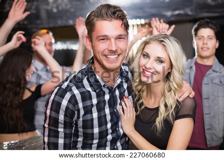 Stylish couple smiling and dancing together at the bar