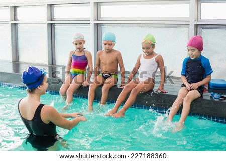 Cute swimming class watching the coach at the leisure center