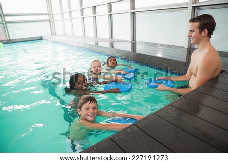 Cute swimming class in pool with coach at the leisure center