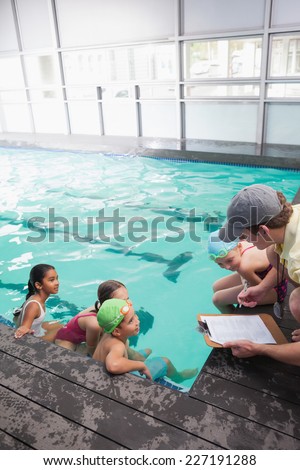 Cute swimming class listening to coach at the leisure center