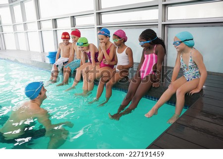 Cute swimming class in pool with coach at the leisure center