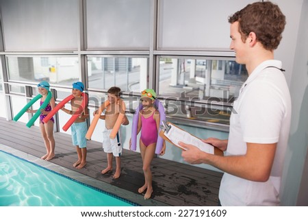 Swimming coach with his students poolside at the leisure center