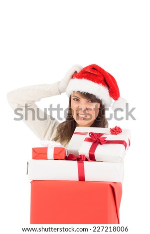 Attractive santa woman scratching head and holding gifts over white background
