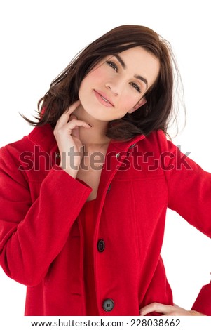 Portrait of a cheerful brunette in red coat on white background