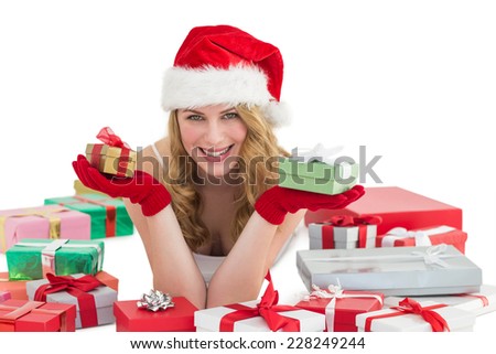 Woman in santa hat laying on the floor while holding gifts on white background