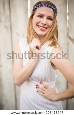 Portrait of a smiling blonde woman wearing headband in front of a wooden wall