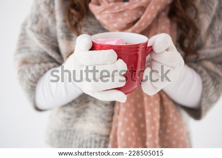 Woman in winter clothes holding a mug on white background on white background