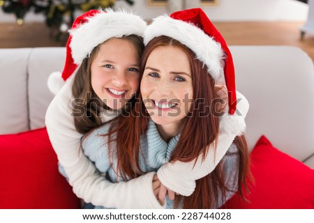Festive mother and daughter on the couch at home in the living room