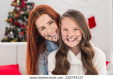 Festive mother and daughter on the couch at home in the living room