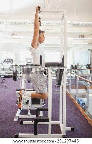Fit man doing pull ups in fitness studio at the gym