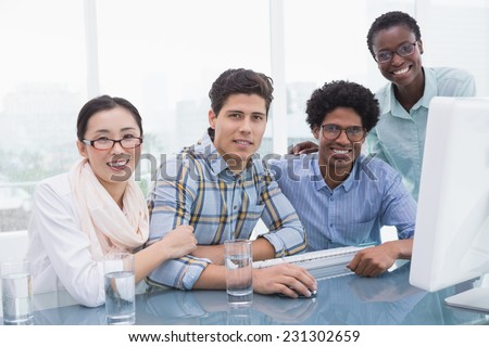 Casual business team working together at desk in creative office