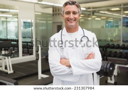 Confident doctor standing in weights room at the gym