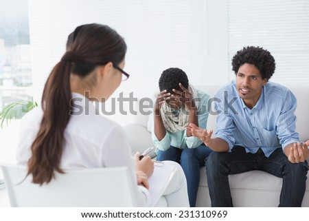 Angry couple talking to their therapist in therapists office