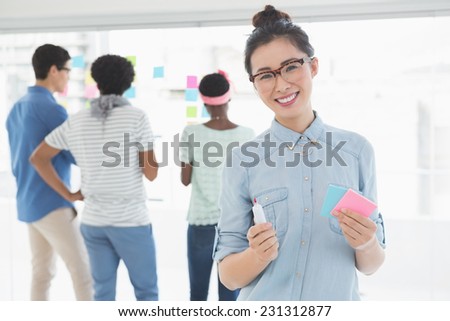 Young creative woman smiling at camera in creative office