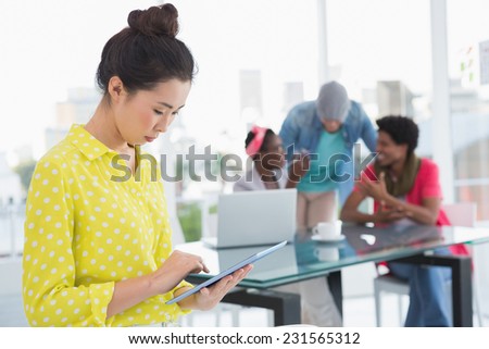 Young creative woman using her tablet in creative office