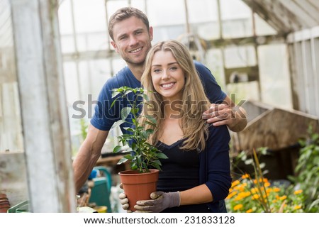 Cute couple gardening in greenhouse at home in the garden