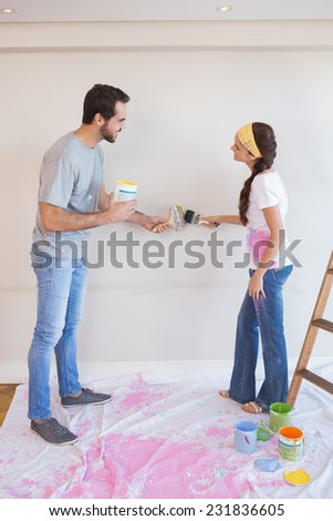 Cute couple painting the wall in their new home
