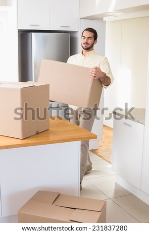 Young man unpacking boxes in kitchen in his new home