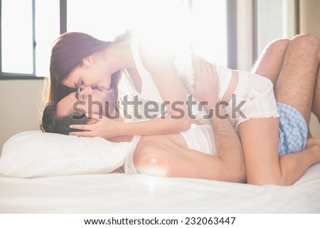 Young couple having fun in bed at home in bedroom