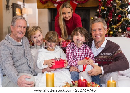 Multi generation family holding presents on sofa at home in the living room