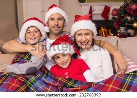 Festive family hugging under the cover at home in the living room