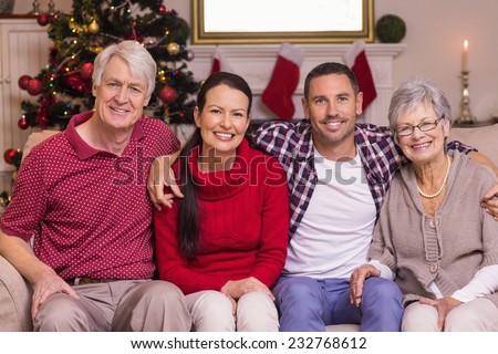 Portrait of a happy family sitting on sofa at home in the living room