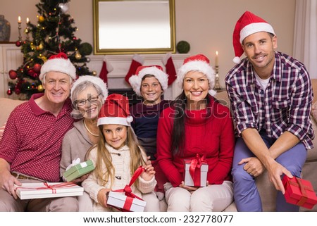 Multigeneration family wearing santa hats on the couch at home in the living room