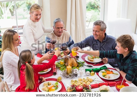 Family toasting with red wine in a christmas dinner at home in the living room