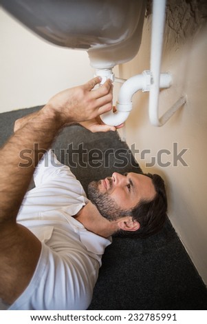 Plumber fixing the sink in a bathroom in a new house