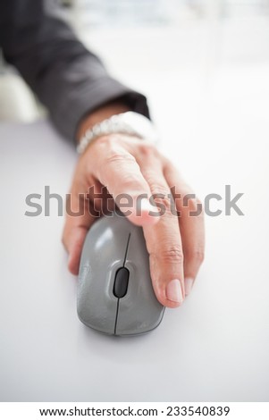 Businessmans hand on computer mouse in his office