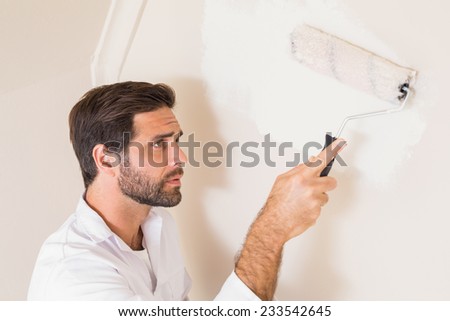 Painter painting the walls white in a new house