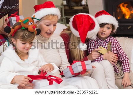 Happy extended family opening gifts on the couch at home in the living room