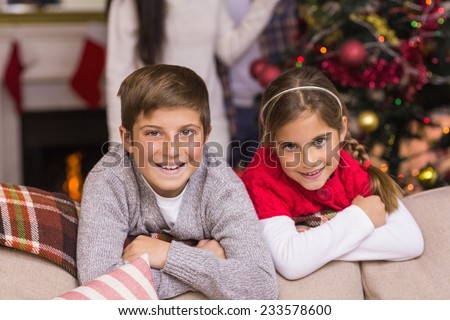 Brother and sister leaning on the couch at home in the living room