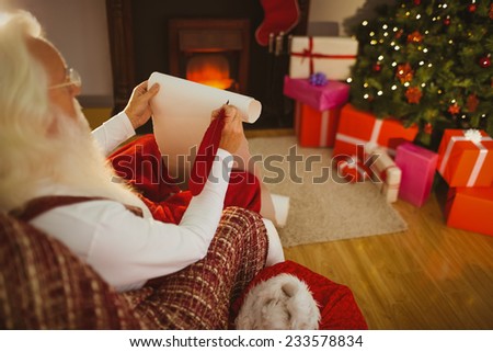 Santa claus holding his list at home in the living room
