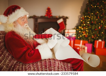 Santa claus writing his list on scroll at home in the living room