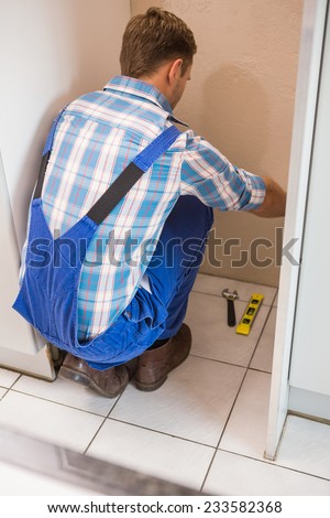 Builder fixing tiles on the floor of a new home