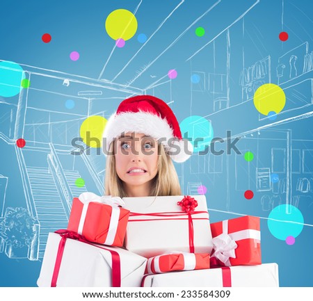Festive blonde holding pile of gifts against blue vignette