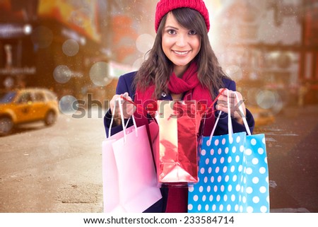 Smiling brunette opening gift bag against blurry new york street