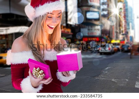 Festive blonde opening a gift against blurry new york street