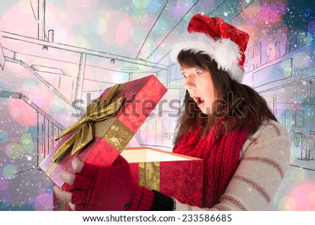 Shocked festive brunette opening a gift against light glowing dots on blue