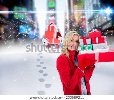 Festive blonde holding many gifts against santa delivering gifts in city