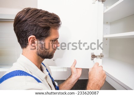 Handyman putting up a shelf in the kitchen