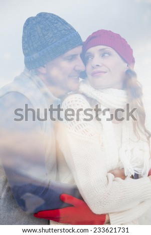 Happy couple in warm clothing seen through glass window