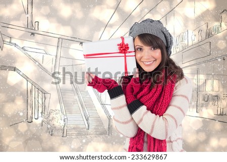 Festive brunette holding white and red gift against light glowing dots design pattern