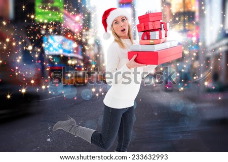 Festive blonde holding pile of gifts against blurry new york street
