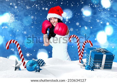 Woman wearing red boxing gloves against christmas scene with gifts and candy canes