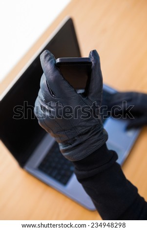 Hands with leather gloves using laptop and smartphone on white background