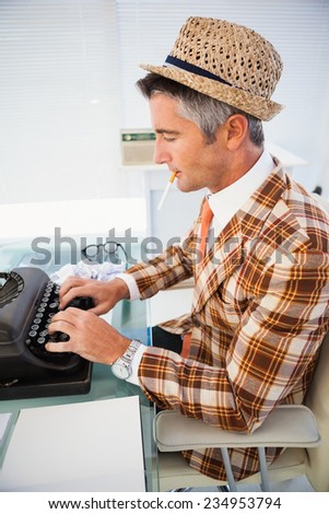 Vintage man in straw hat typing on typewriter in his office