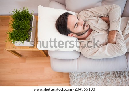 Man sleeping on the couch with arms crossed in the living room